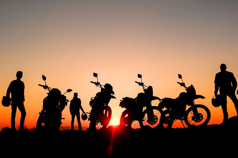 Motorräder und Fahrer beim Sonnenuntergang