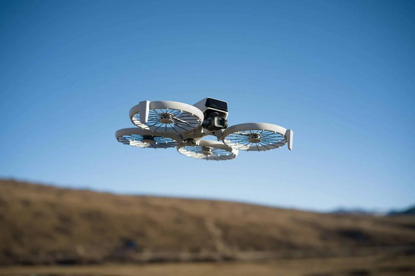 DJI Flip with propeller guards flying against a blue sky