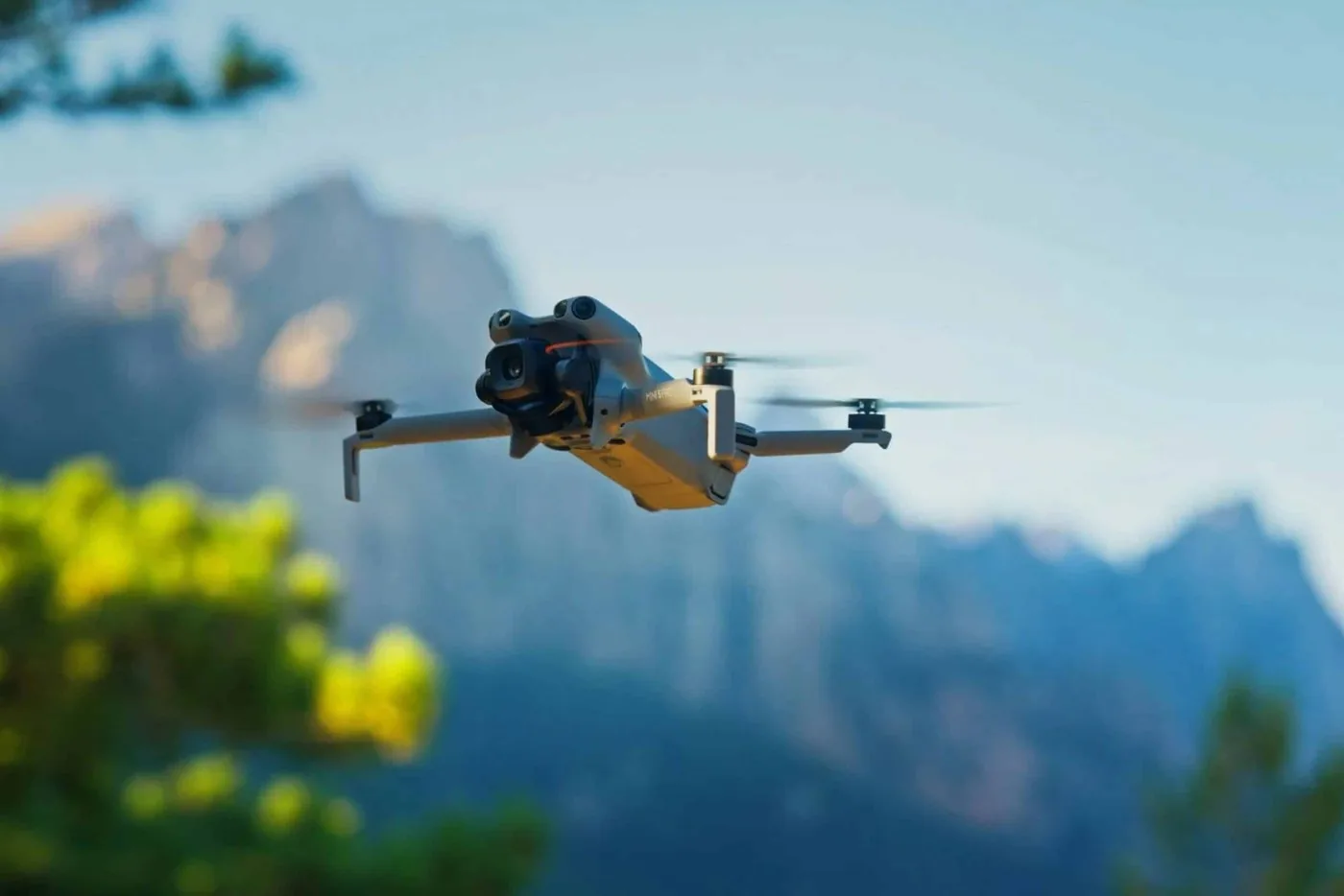 DJI Mini 5 Pro in flight against a mountain backdrop