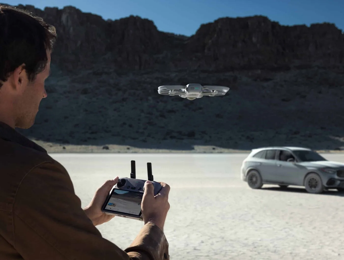 Pilot flying a drone with a remote controller outdoors