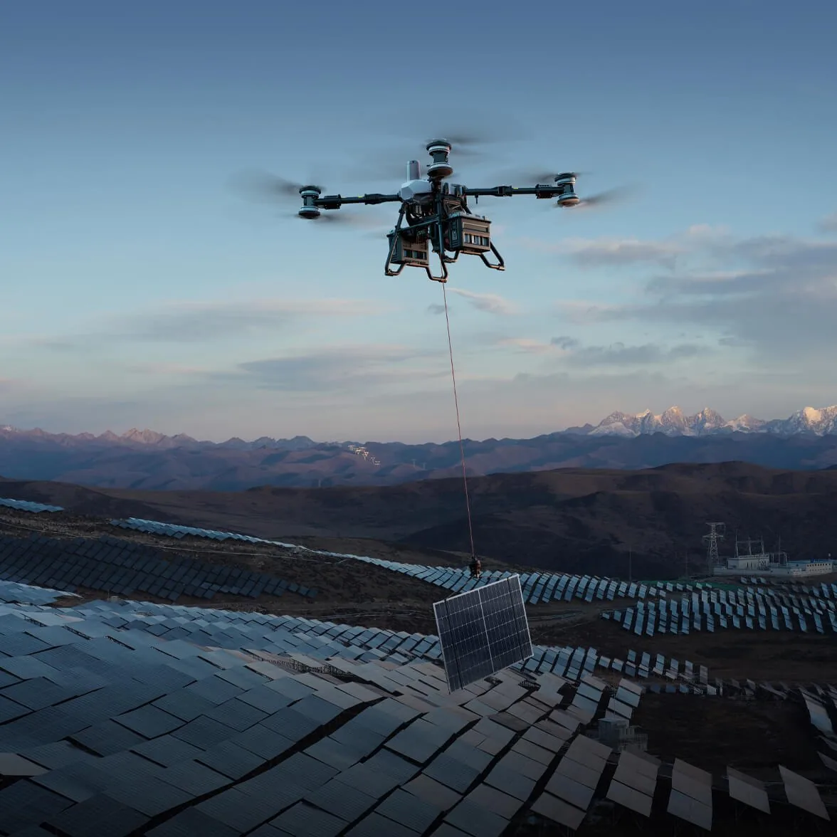 Cargo drone lowering a solar module on its winch over a solar farm