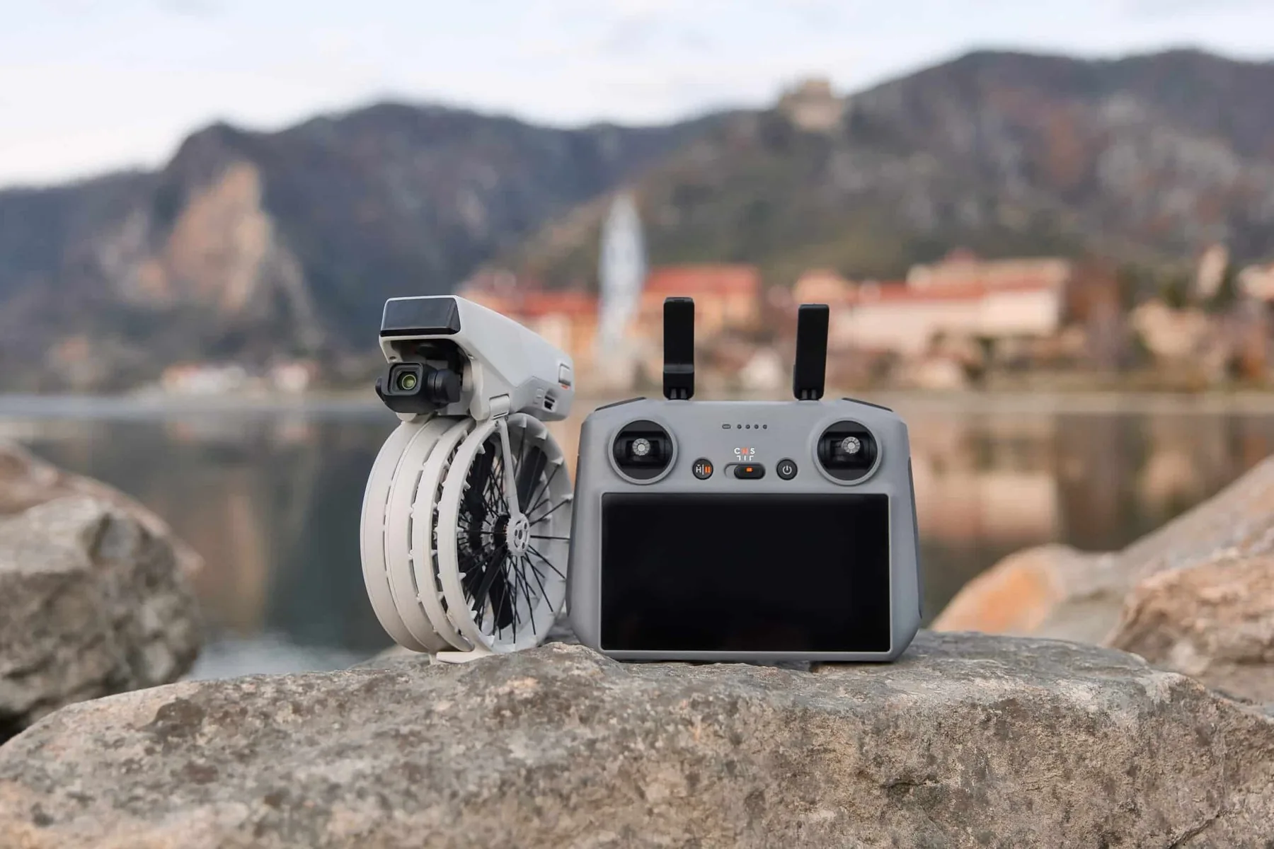 DJI drone and remote controller on a rock, with lakes in the background
