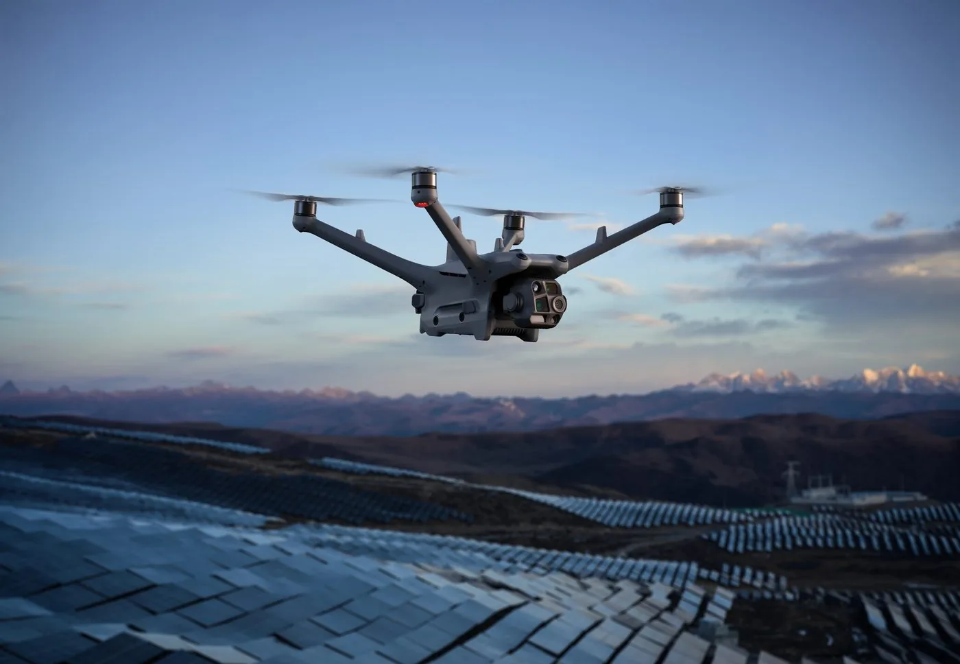 Industrial drone flying over a solar farm in the mountains