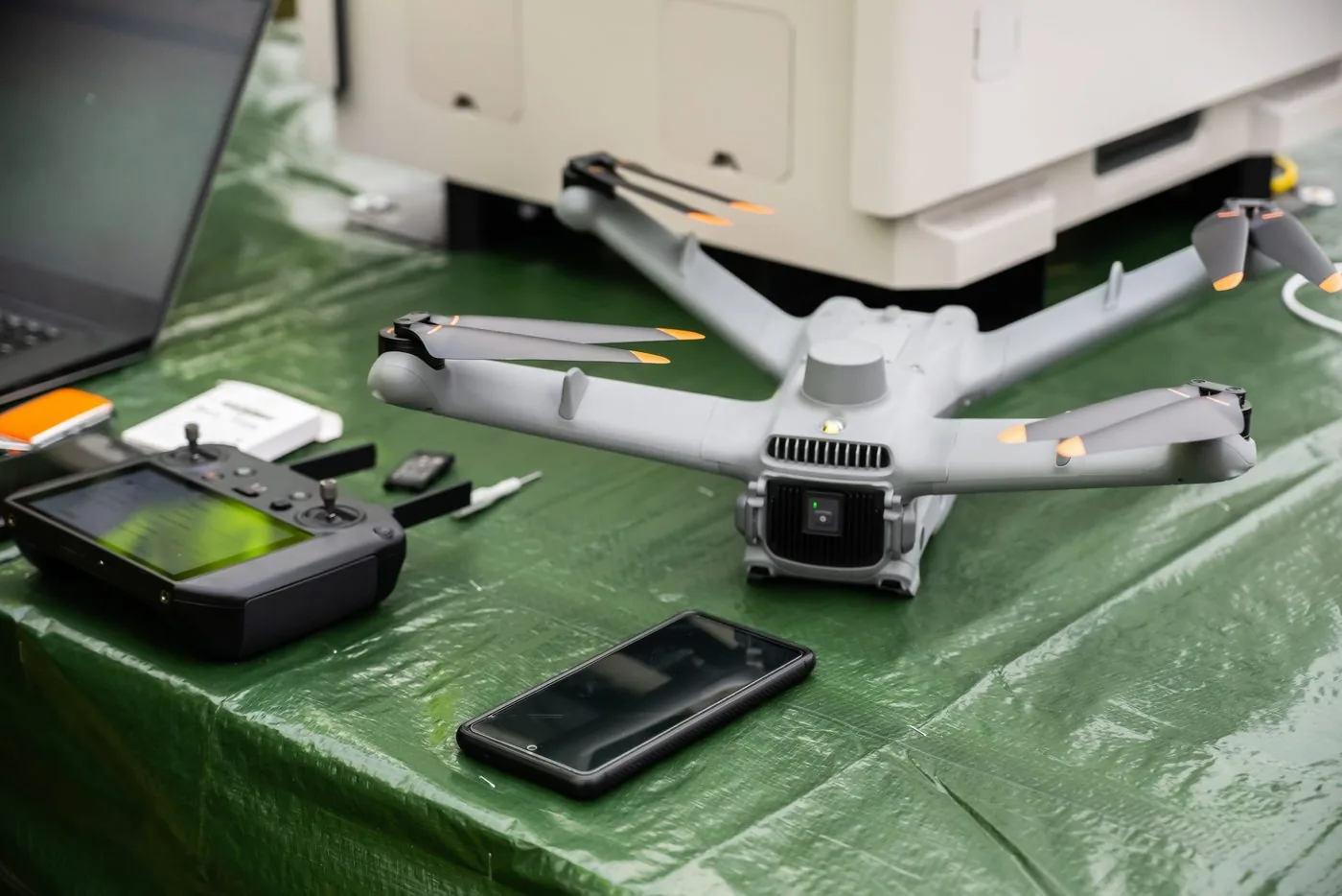 Drone, remote controller and smartphone on a work table outdoors
