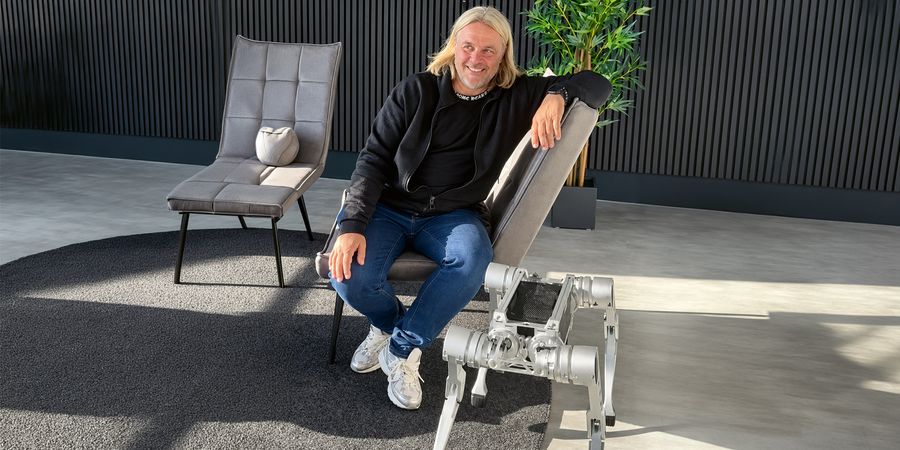 Olaf Kappler im Showroom, vor ihm ein Laufroboter