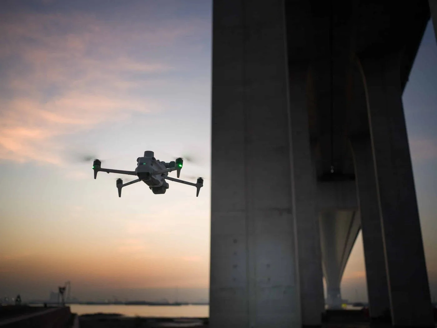 Industrial drone with a spotlight under a bridge at dusk
