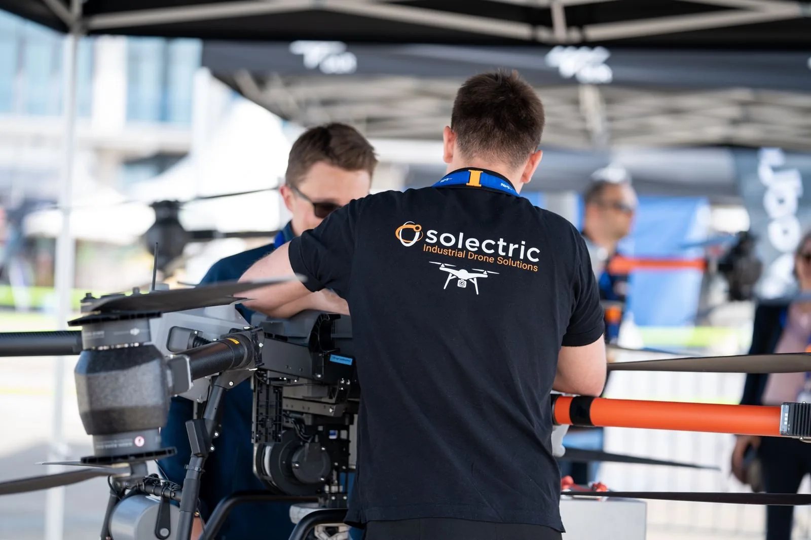 Solectric technician preparing an industrial drone with a camera payload